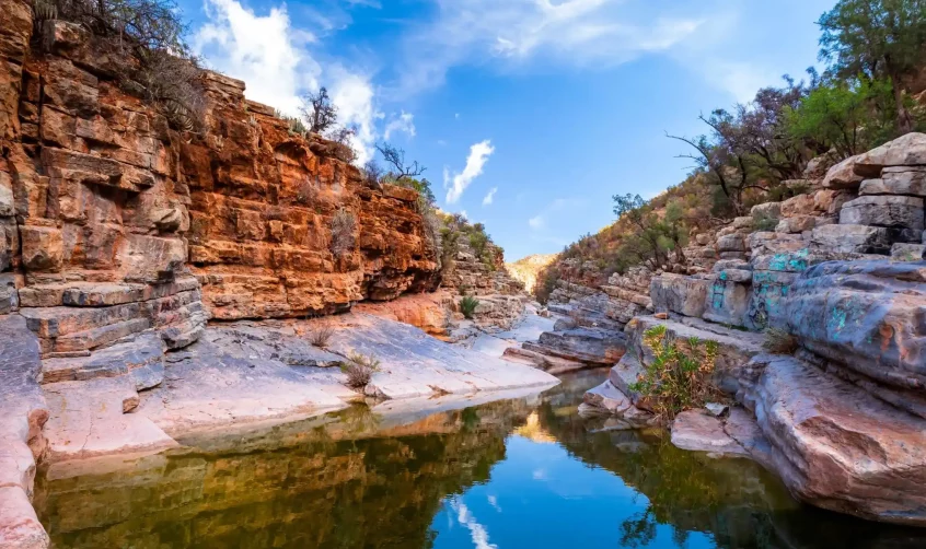 Serene waters and red cliffs of Paradise Valley, Morocco