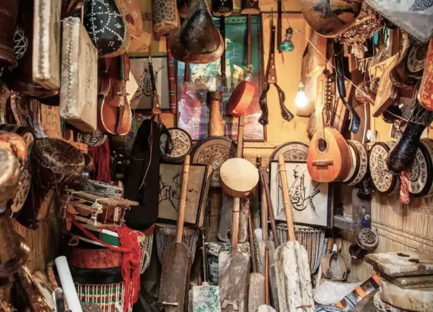 Une collection d'instruments de musique marocains traditionnels, notamment des tambours, des luths et d'autres instruments à cordes, mettant en valeur le riche patrimoine culturel du Maroc. Ces instruments font partie intégrante de la scène musicale de Rabat, où la musique arabo-andalouse continue de prospérer.