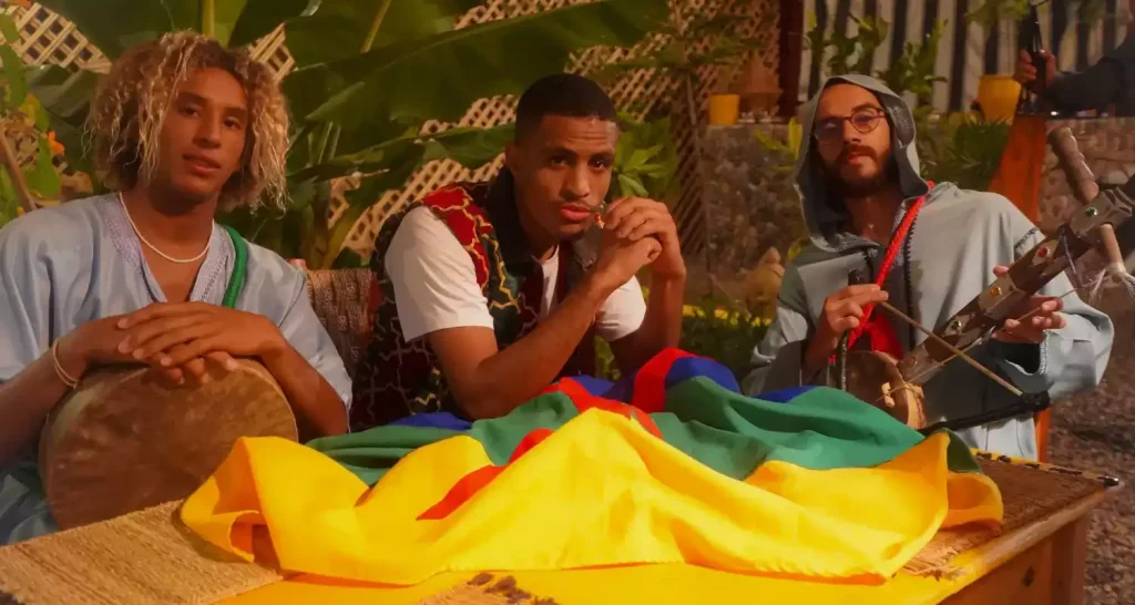 Young Amazigh musicians with traditional instruments and a coloured flag preparing music for Berber New Year celebrations.