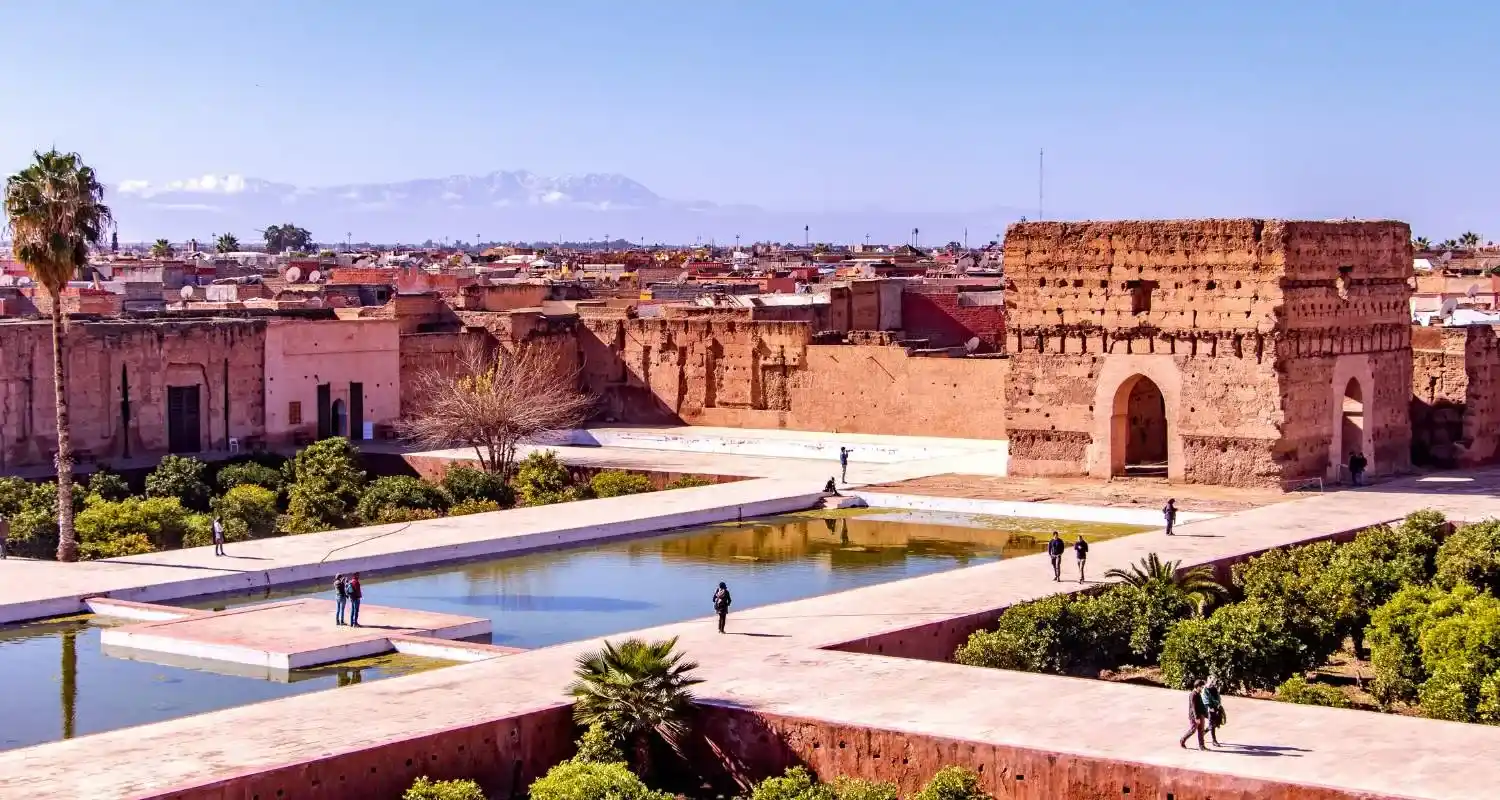 El Badi Palace courtyard with reflecting pools, sunken gardens, and Atlas Mountains in the background