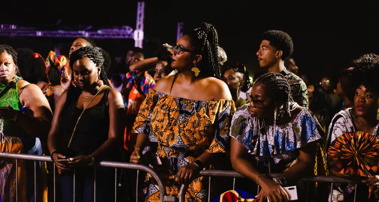 Le public du Festival Gnaoua 2026, vêtu d'imprimés africains traditionnels, assiste à un concert nocturne à Essaouira.